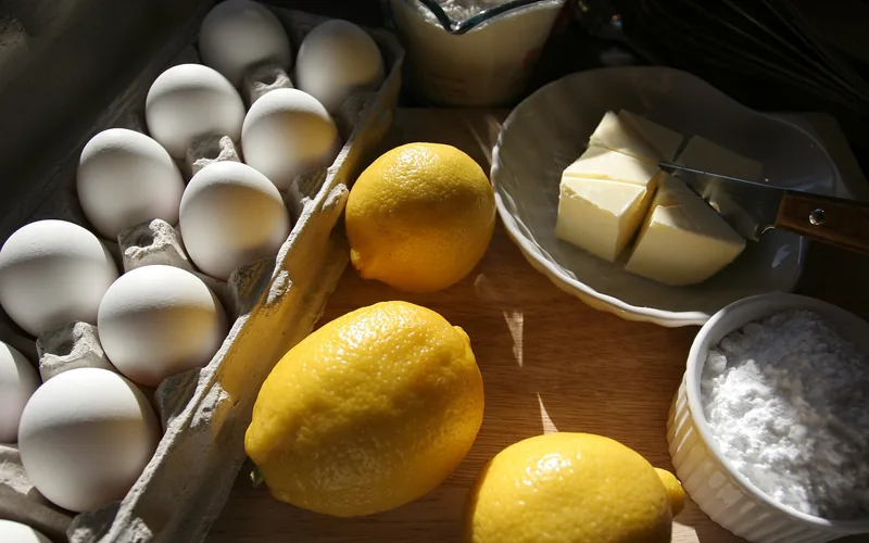 Limones, huevos y mantequilla sobre una tabla